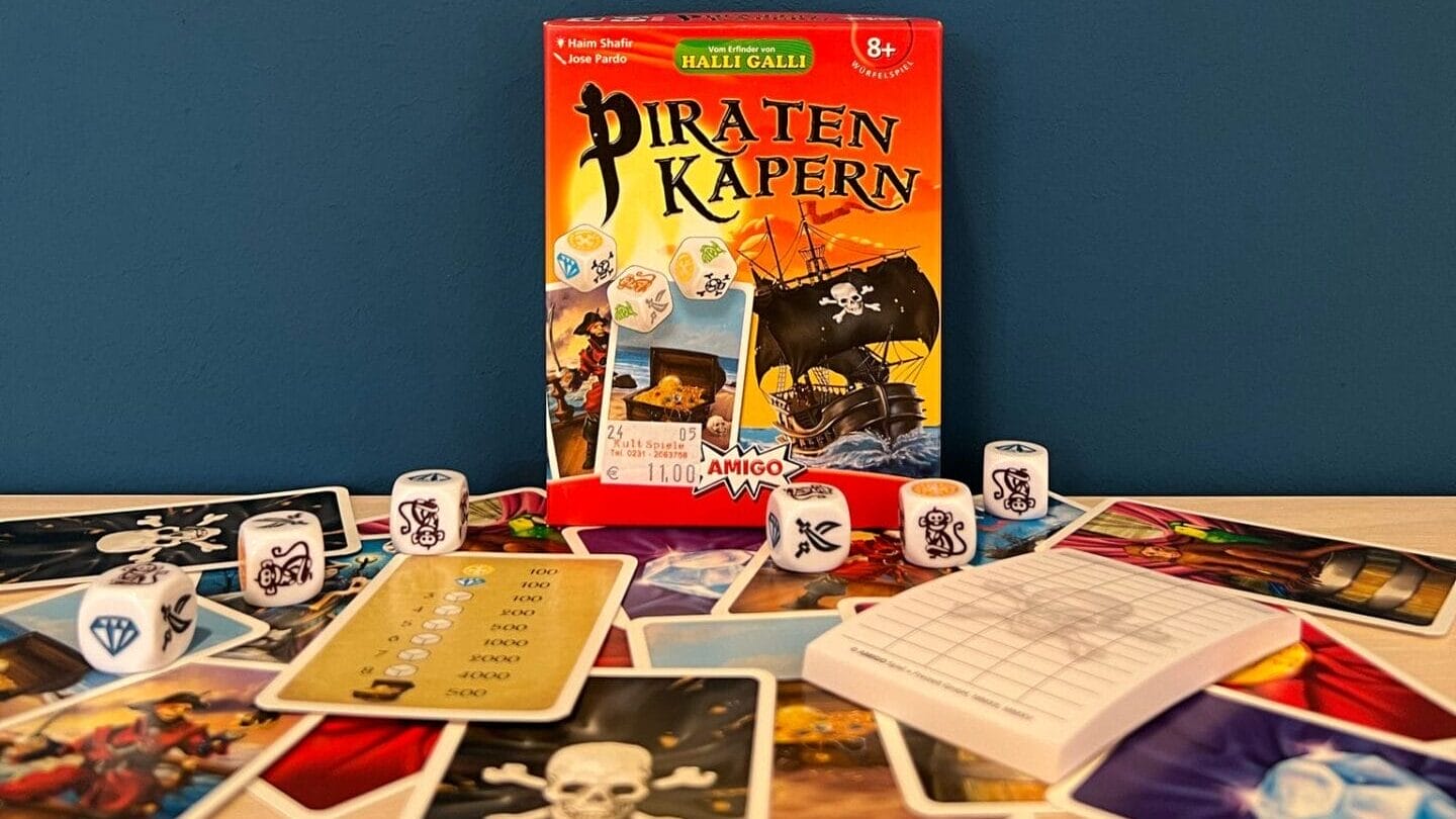 Das Brettspiel "Piraten Kapern" steht auf einer Platte mit seinen Bestandteilen davor ausgebreitet.